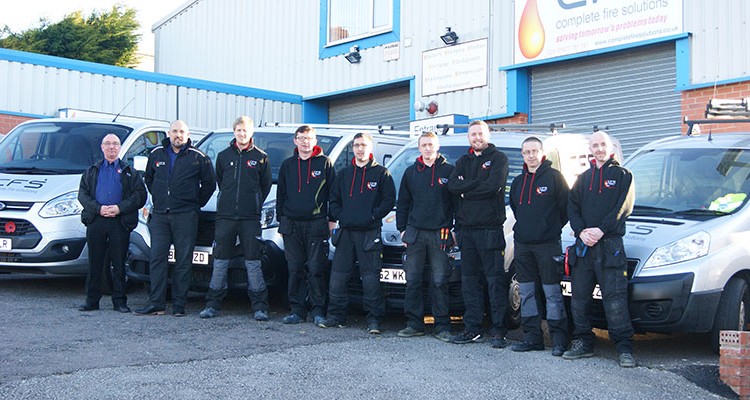 The team at Complete Fire Solutions stood in fron tof the van fleet.